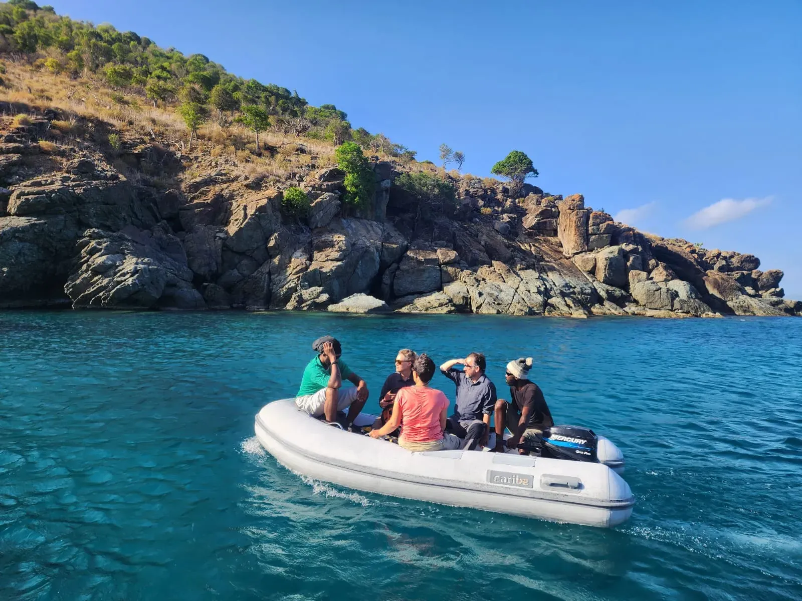 A team in a dinghy approach an island