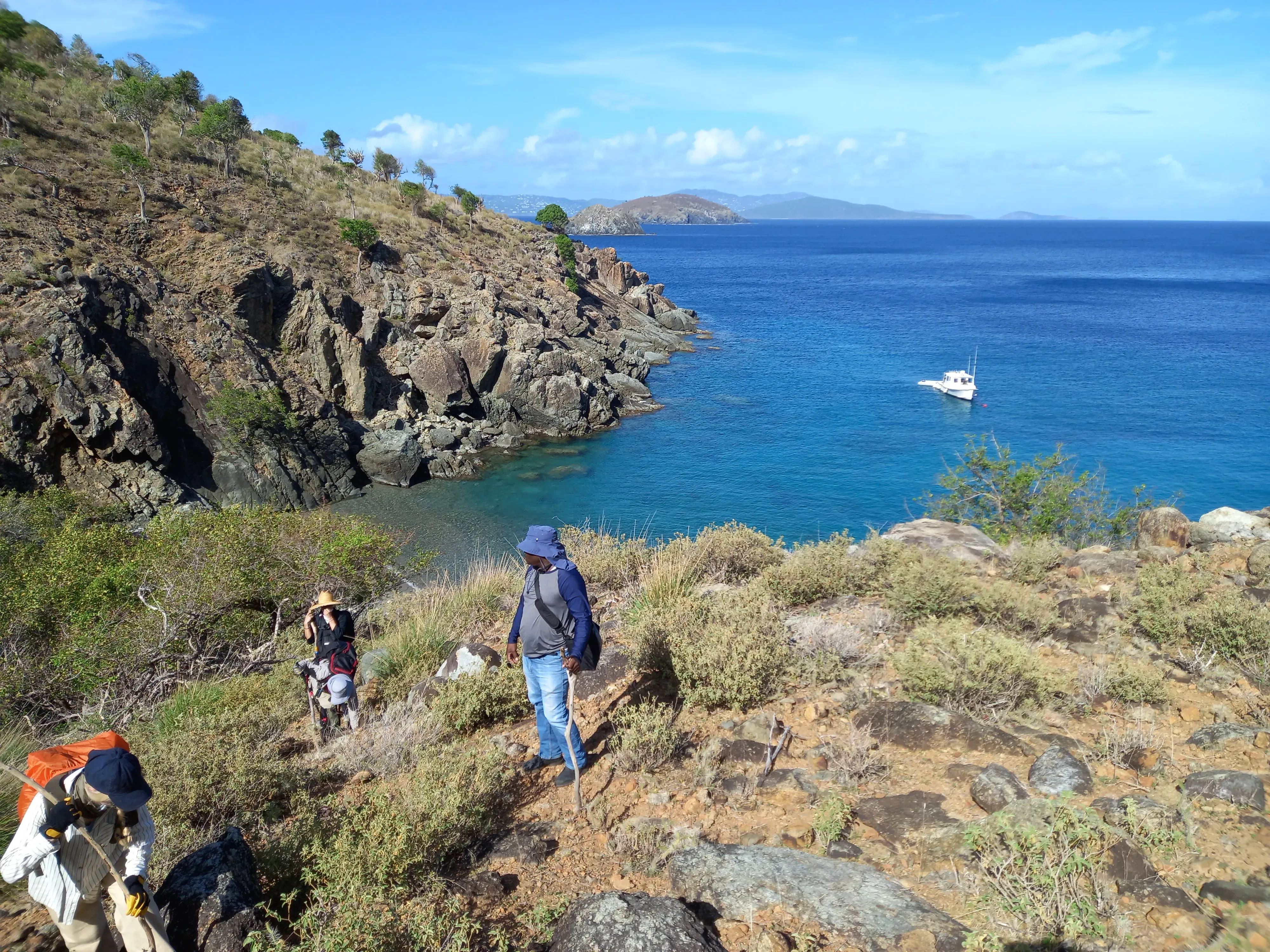 Team in a setting of rock and scrub with the sea in the background